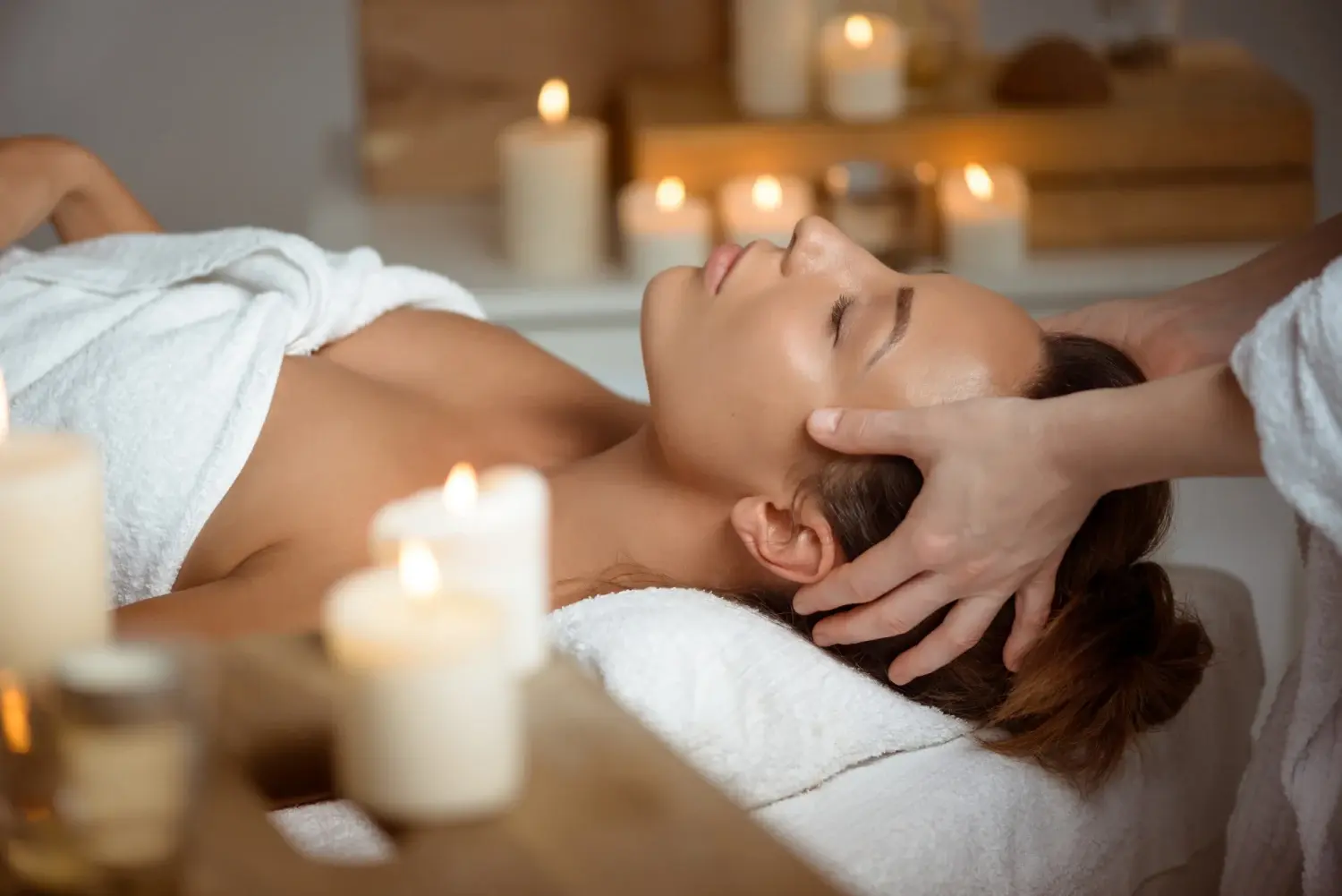 A guest receiving a candlelit head massage at Whispering Waters Spa