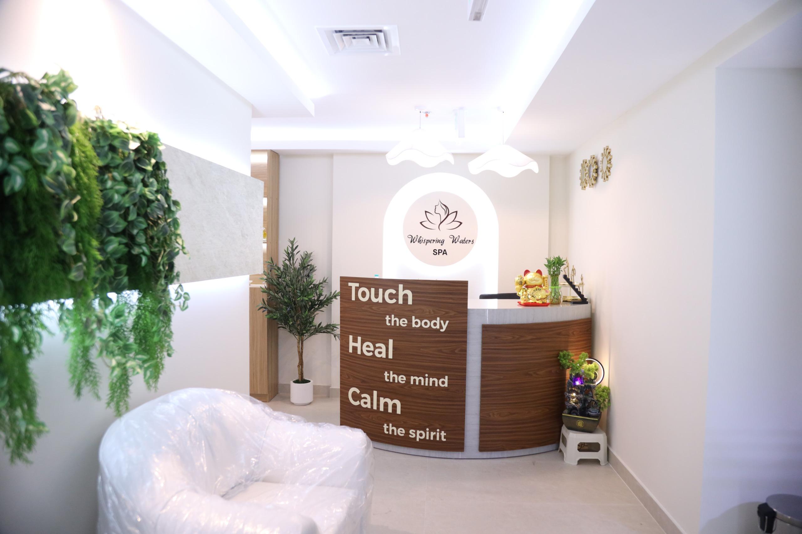 Whispering Waters Spa reception, framed by the words Touch the body, Heal the mind, Calm the spirit